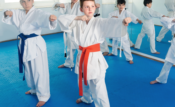 Alumnos practicando una kata durante una clase de artes marciales en el dojo.